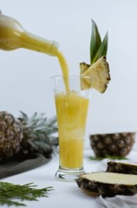 a pineapple drink being poured into a glass