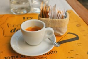 Uma xícara de sopa em um pires sobre uma mesa